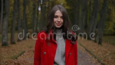 美丽的白种人女人，穿着红色外套，在秋天的森林里，用纸出售<strong>标语</strong>牌
